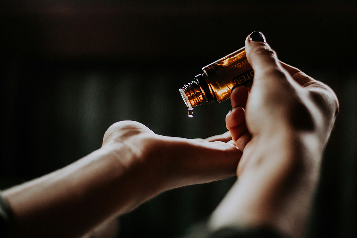 Woman applying a drop of essential oils to her palm- photo by Christin Hume- Kai interiors Hackney