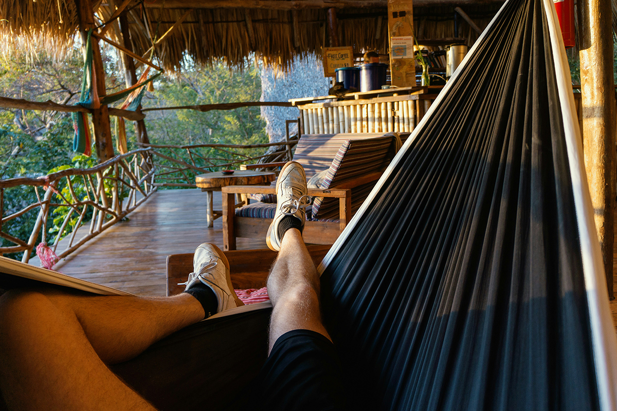 Sleep Tourism- Man sleeping in hammac in a Tree house - Photo by Tobias Tullius-Kai interiors Hackney